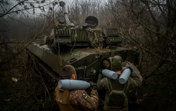 Українські військові завантажують боєприпаси в танк у лісі на Александровському напрямку