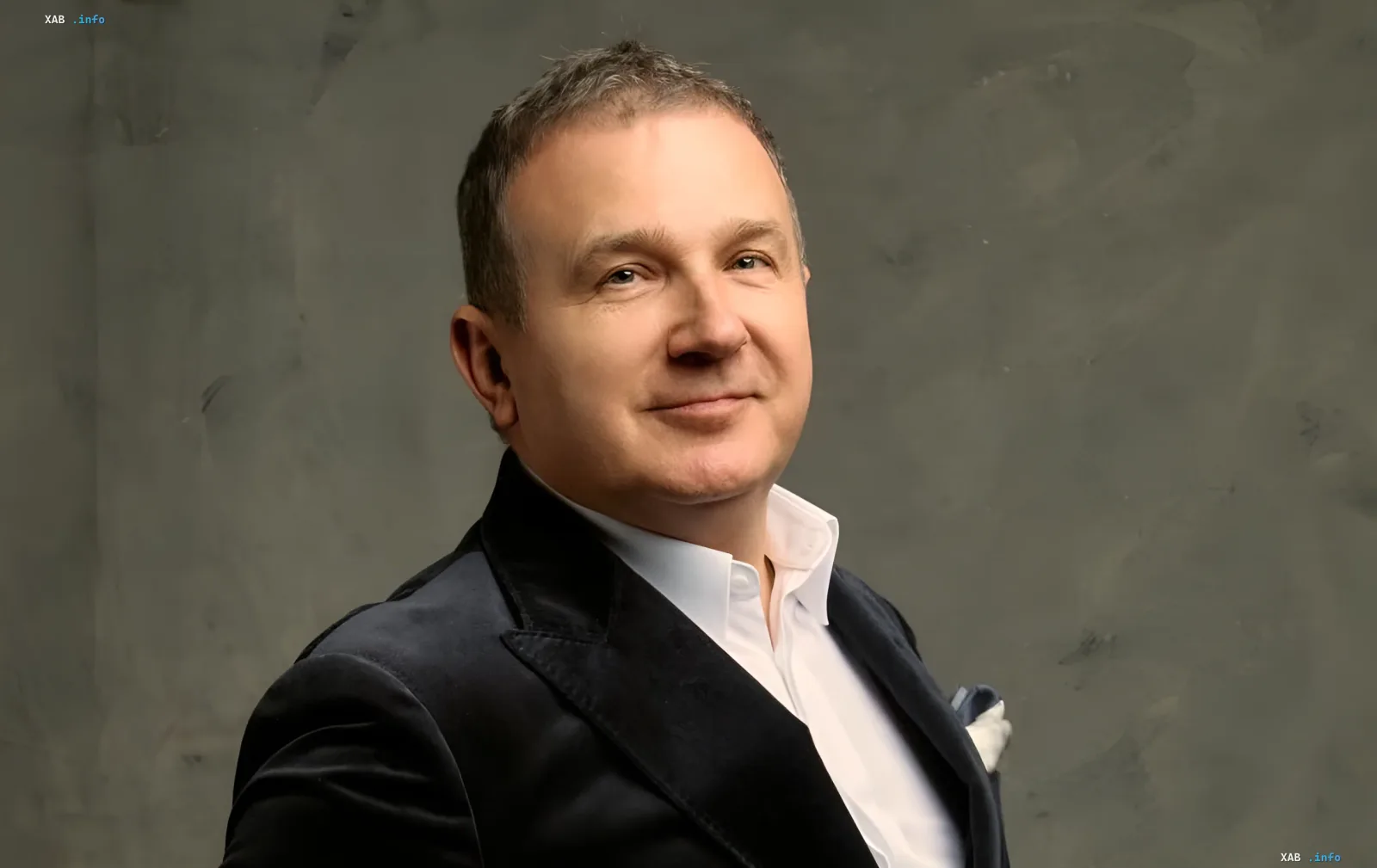 Юрий Горбунов в официальном костюме на фоне серой стены — актер обсуждает украинское кино и проект «Скажене Різдво»