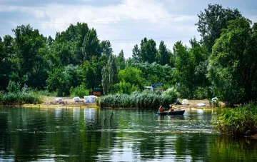 Arbeiter auf einem Boot reinigen den Fluss Irpin nach einer ökologischen Katastrophe, die zum Massensterben von Fischen führte