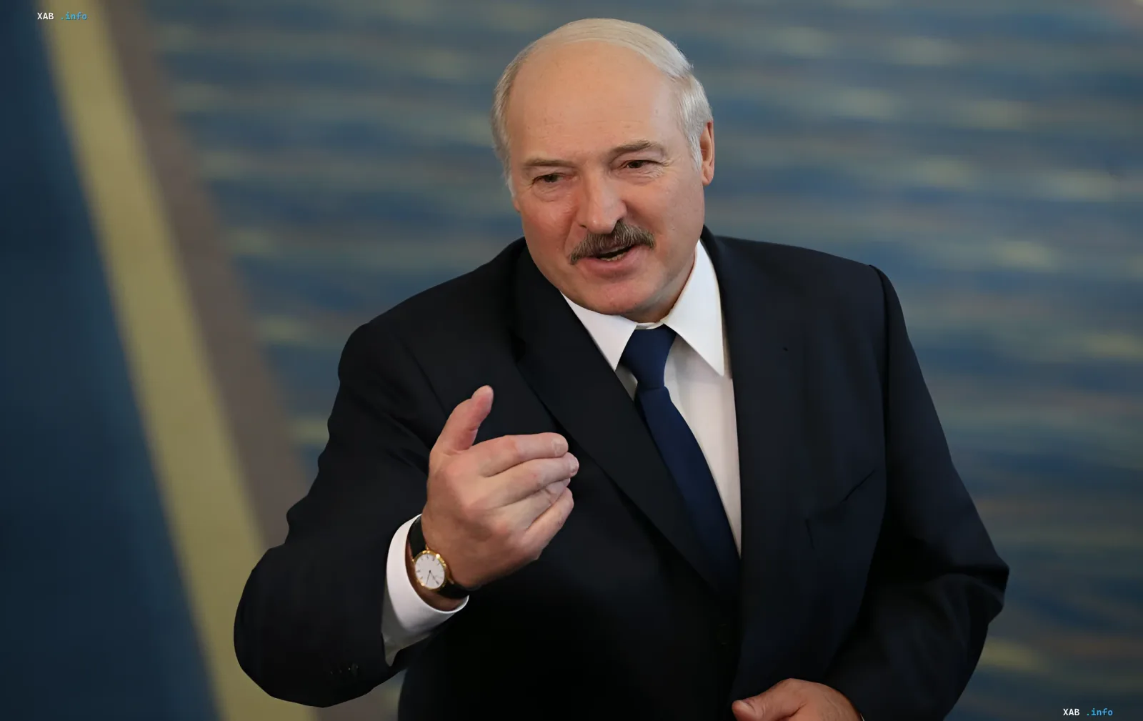 Александр Лукашенко в деловом костюме жестикулирует во время переговоров, что символизирует возможные дипломатические шаги Киева ради спасения жизней