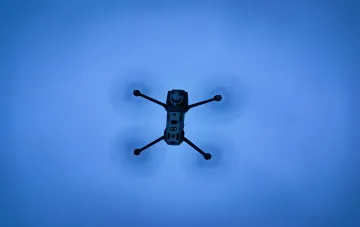 Drohne im Flug vor blauem Himmel — Illustration zum Artikel darüber, wie Lockheed Martin das 5G-Netz von Verizon in einen NetSense-Radar zur Drohnerkennung umgewandelt hat