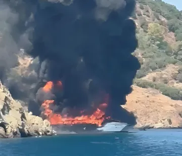Пожежа на катамарані Toys Boat у Фет'є: полум'я охоплює судно, густий чорний дим піднімається над морем, туристи рятуються стрибком у воду