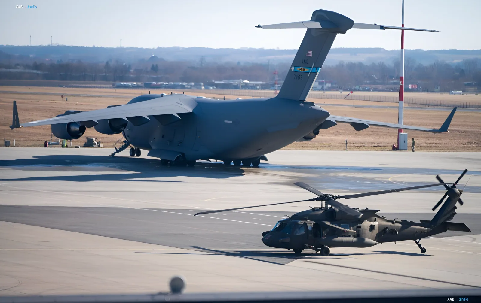Бойовий вертоліт Apache на аеродромі поруч із транспортним літаком C-17 — ілюстрація до новини про катастрофу в Техасі