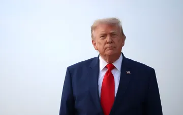 Дональд Трамп в синем костюме и красном галстуке на фоне неба — фото, связанное с тайной эвакуацией из Анкары из-за угрозы ПЗРК