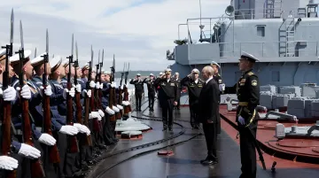 Владимир Путин во время инспекции почетного караула на борту военного корабля в порту Итуруп