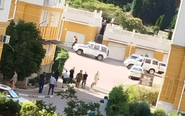 Сцена задержания в Севастополе: сотрудники правоохранительных органов и военные у дома, где произошел взрыв; рядом стоят полицейские автомобили, видны следы оперативной работы