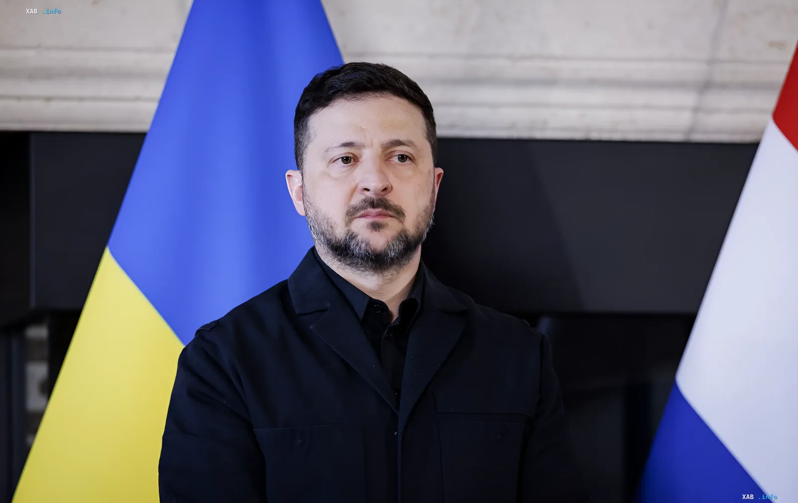 Президент Украины Владимир Зеленский на фоне флагов Украины и Франции, обсуждающий условия мирного плана с акцентом на давление США на Путина