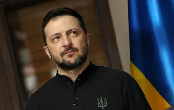 Ukrainischer Präsident Wolodymyr Selenskyj in Gedanken versunken vor dem ukrainischen Flaggenhintergrund, diskutiert Geldpolitik und IWF-Loyalität