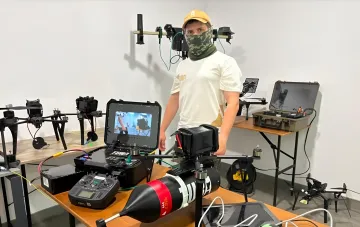 Инженер Brave1 демонстрирует новые модульные FPV-дроны с боевой частью в лаборатории