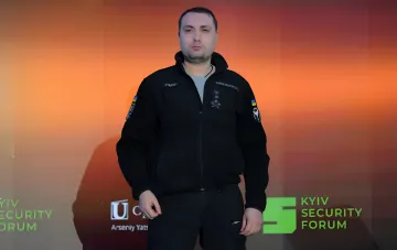 Кирилл Буданов, глава ГУР, на фоне логотипа Kyiv Security Forum — символ украинской безопасности и требований компенсаций от России