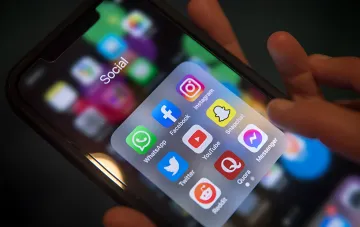 Смартфон с папкой «Social», содержащей иконки популярных соцсетей — символ дискуссии о запрете соцсетей для детей до 15 лет во Франции
