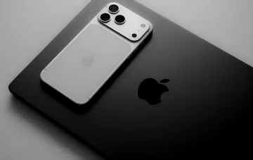 Концепт белого iPhone 18 с тремя камерами на черном MacBook, иллюстрирующий возможный дизайн базовой модели Apple в 2027 году