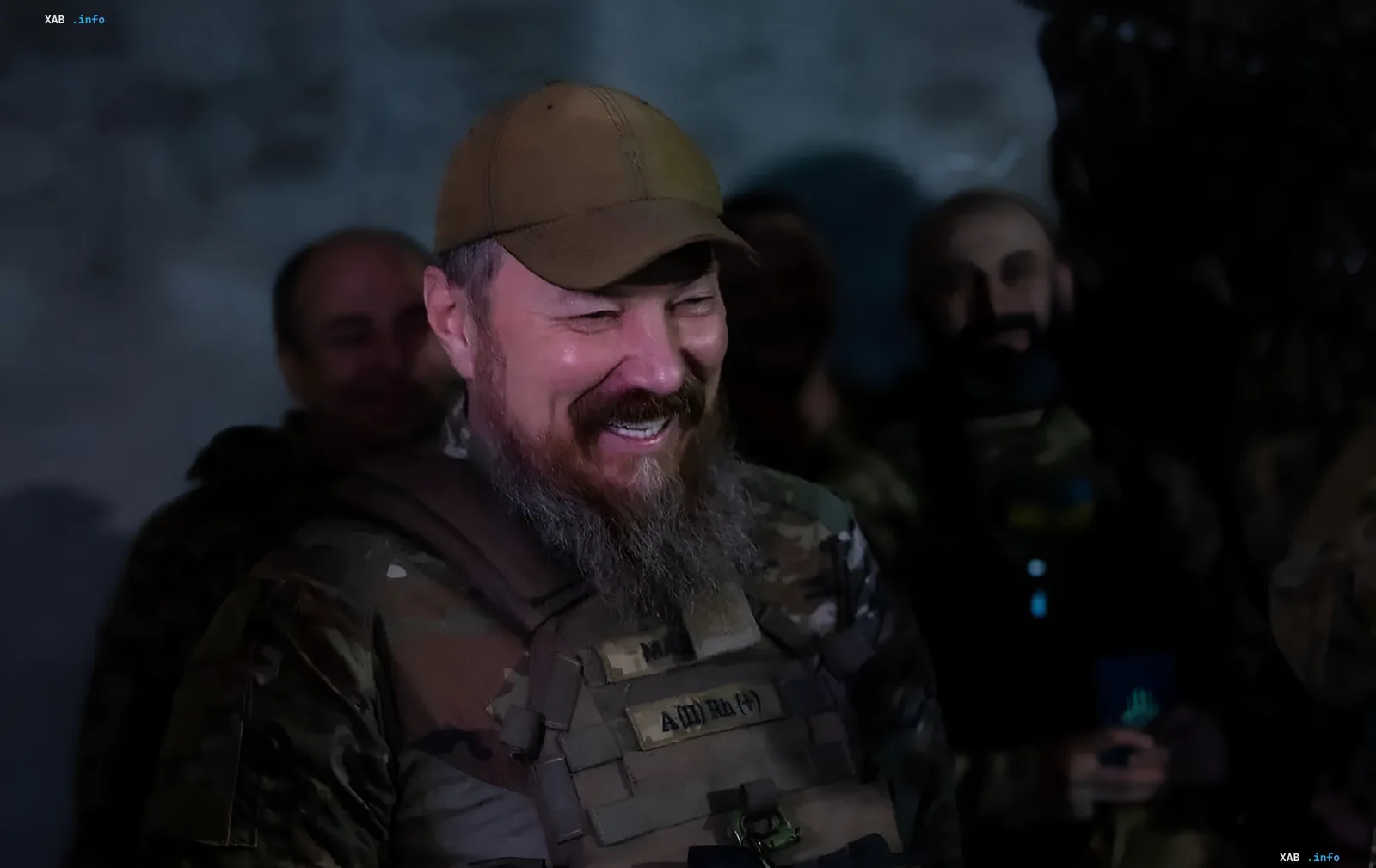 Командир украинских Сил специальных операций в камуфляже и берете, улыбающийся на фоне других бойцов, символизирующий успех операции «Крымский рубильник» по обесточиванию энергоузлов РФ