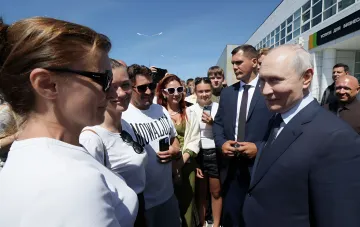 Владимир Путин во время визита на Итуруп общается с местными жителями на фоне здания аэропорта