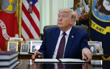 Donald Trump at his desk in the Oval Office reviewing documents — in context of the administration’s Supreme Court petition to approve construction of a ballroom at the White House