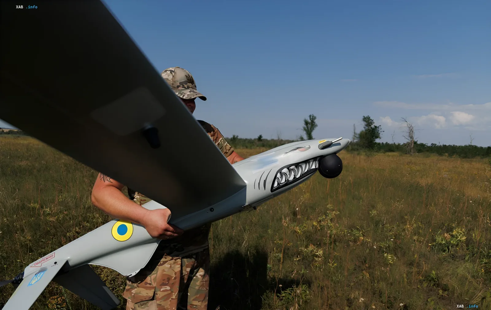 Украинский военный готовит к запуску разведывательный дрон с символикой ВСУ на фоне поля, иллюстрируя тему борьбы с ретрансляторами противника
