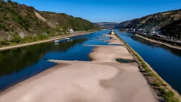 Austrocknung des Rheins: Luftaufnahme von ausgedehnten Sandbänken und einem feststeckenden Bagger, die den kritischen Rückgang des Wasserstands und die Gefahr für die Schifffahrt zeigen