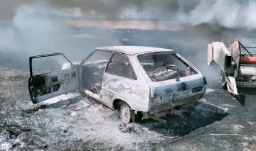 Verbrannte Überreste eines Autos und eines Mähdreschers nach Drohnenangriff in der Region Saporischschja