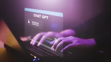 Hände tippen auf einer Laptop-Tastatur mit holografischem ChatGPT-Interface, das symbolisiert, wie KI das Leben eines Teenagers in Brasilien rettete, indem sie einen Mordanschlag verhinderte