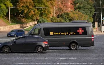 Серый фургон Красного Креста с надписью 'ЕВАКУАЦІЯ ДІТИ' на улице Николаева, остановленный полицией в ходе инцидента с задержанием водителя