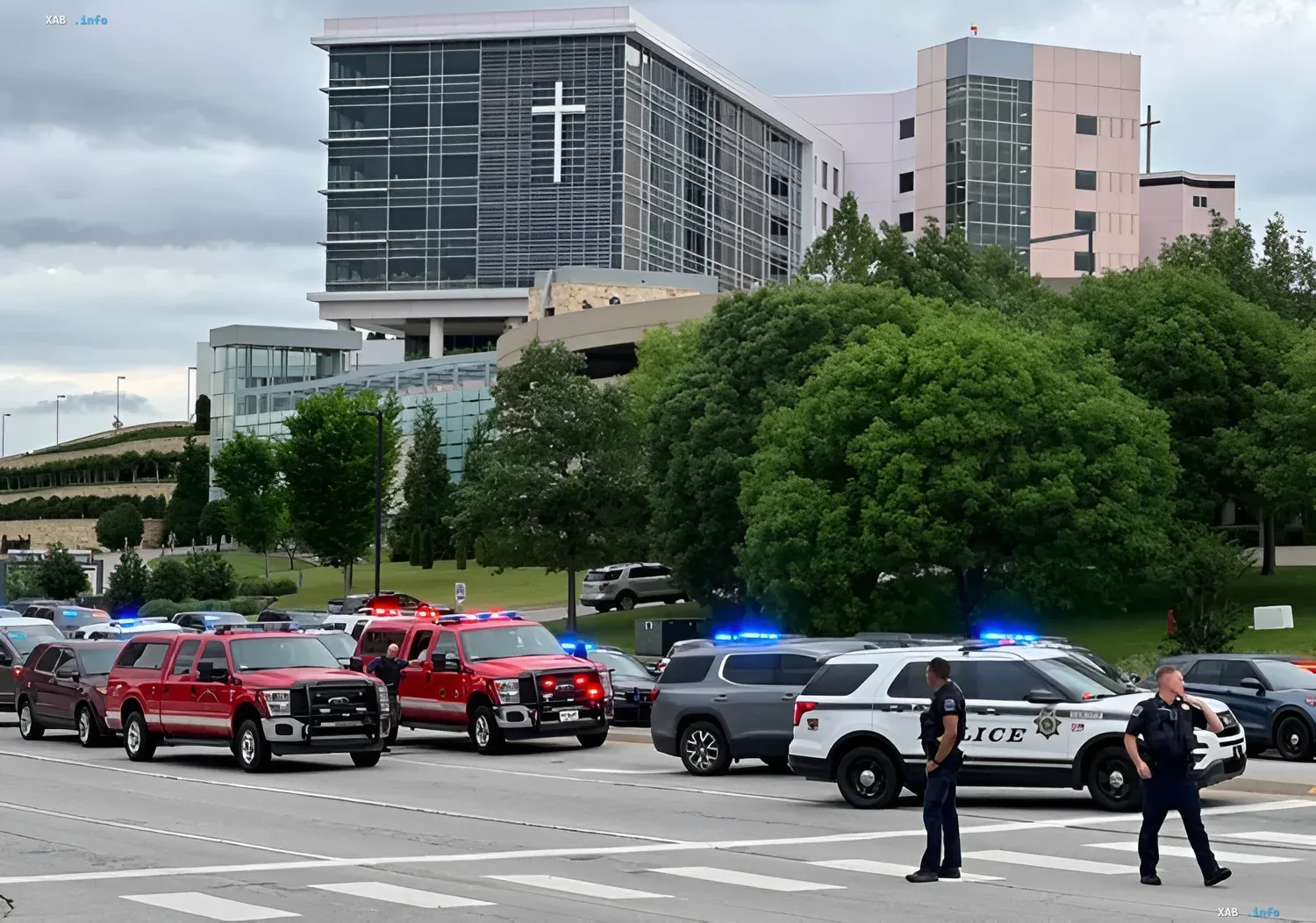 Polizei- und Feuerwehrfahrzeuge am Ort eines Vorfalls vor einem modernen Gebäude mit Kreuz, im Zusammenhang mit dem Schussvorfall in Michigan und Idaho