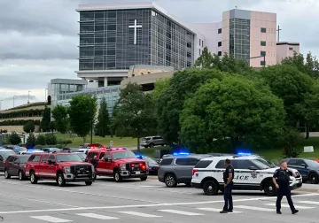 Polizei- und Feuerwehrfahrzeuge am Ort eines Vorfalls vor einem modernen Gebäude mit Kreuz, im Zusammenhang mit dem Schussvorfall in Michigan und Idaho
