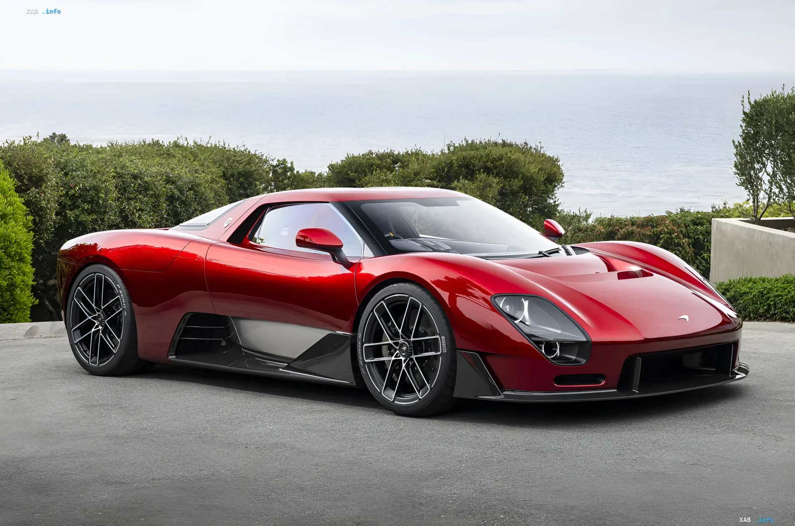Red McLaren McLaren 6GT against a coastal backdrop, showcasing classic design and a manual transmission