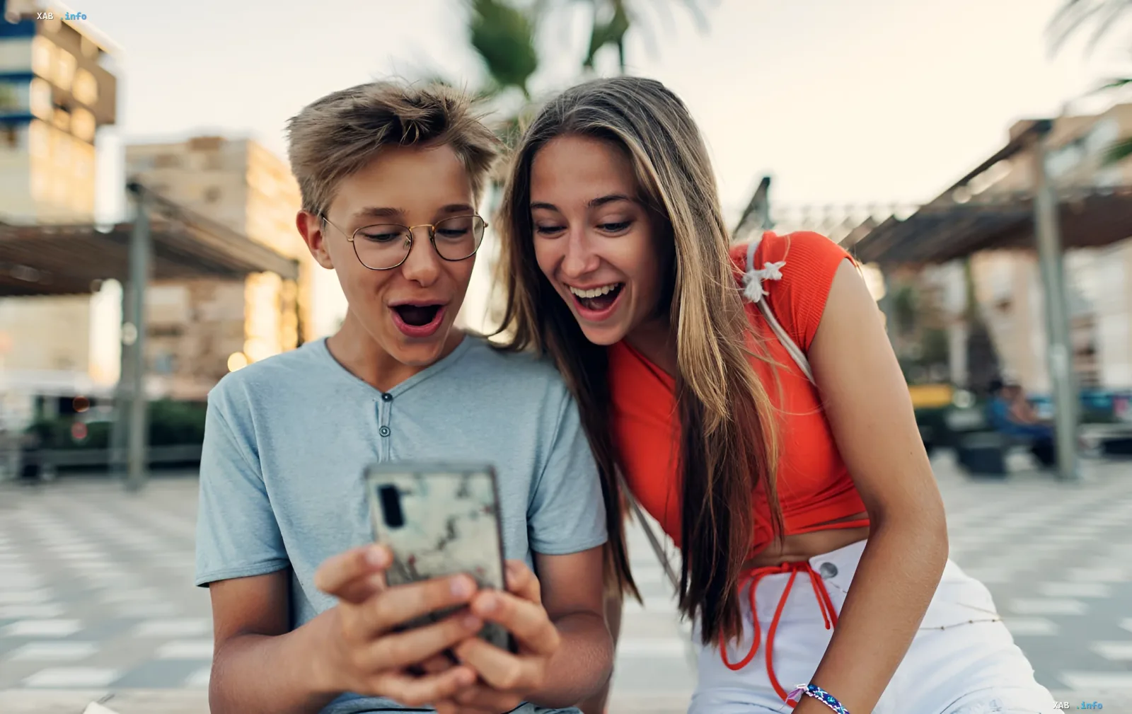 Teenager staunen über ein Smartphone, auf dem möglicherweise eine optische Täuschung mit den Zahlen 896 und 869 zu sehen ist, die die Aufmerksamkeit trainiert