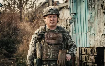 Emil Ischkulow in Kampfausrüstung vor einem zerstörten Gebäude, bereit für die Verteidigung von Slowjansk und Kramatorsk