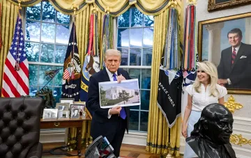 Дональд Трамп в Овальном кабинете держит план военного комплекса, требуя у Верховного суда права на строительство без одобрения Конгресса