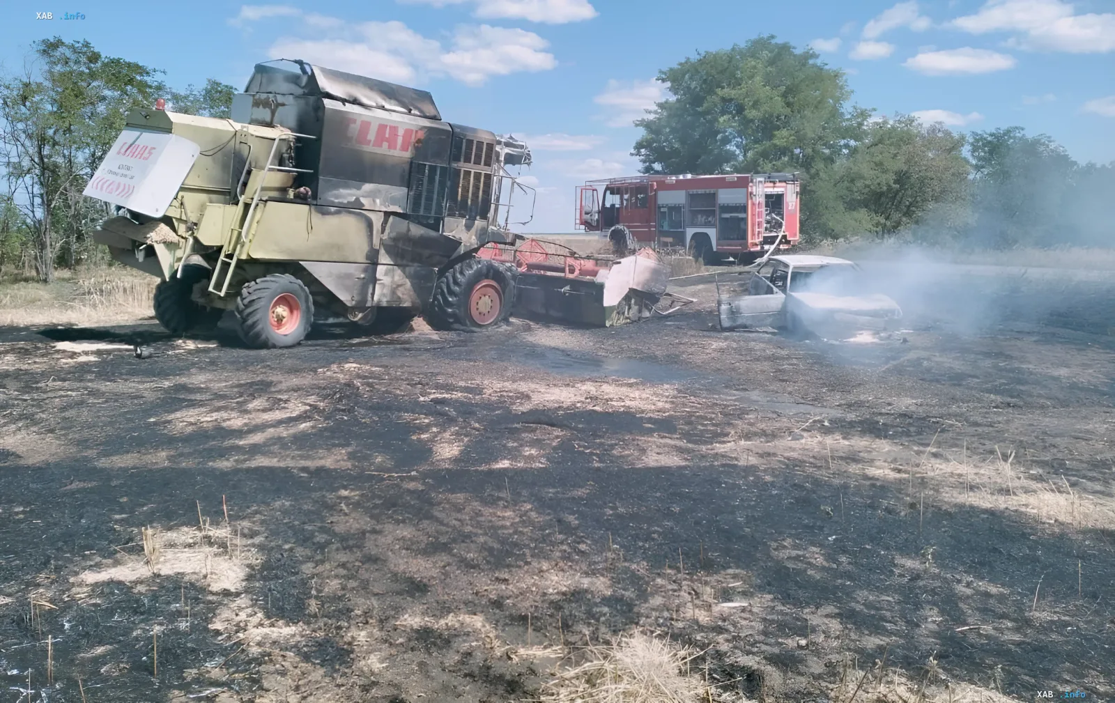 Сгоревший зерноуборочный комбайн Claas и автомобиль после удара дрона в Запорожском районе, пожарные на месте происшествия