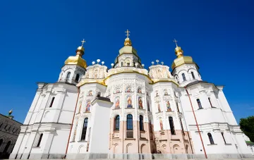 Золотые купола Успенского собора Киево-Печерской лавры на фоне ясного неба — место предстоящей литургии в честь Успения Пресвятой Богородицы в 2026 году