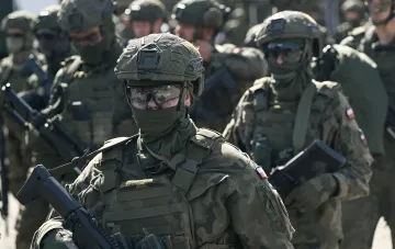 Polish soldiers in camouflage uniforms and armed at a military parade in Poland with NATO participation