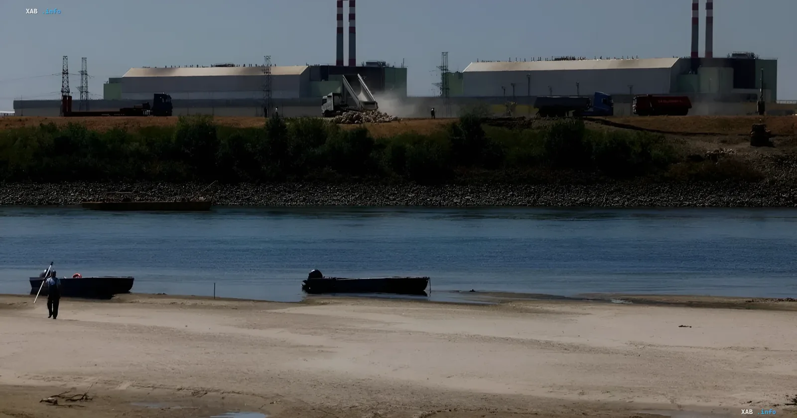 Paks Kernkraftwerk mit Baggern am Fluss, die zur Kontrolle des Wasserstands bei Dürrebedingungen eingesetzt werden