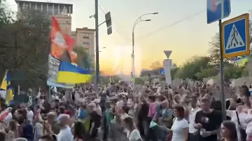 Многочисленная толпа участников «Картонного марша» с украинскими флагами на улице Киева в 32-й день протестов за возвращение Михаила Федорова