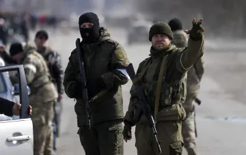Военные с оружием на фоне размытого города, иллюстрирующие фальсификацию побед Кремлем с помощью ИИ