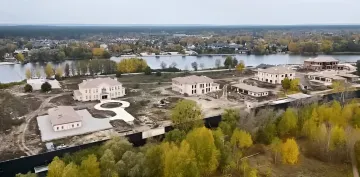 Виллы и особняки в элитном районе на фоне реки, иллюстрирующие объекты, подлежащие налогообложению по новым правилам 2026 года