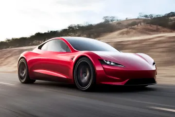 Roter Tesla Roadster 2026 in Bewegung auf einer Straße, zeigt futuristisches Design und Aerodynamik