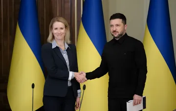 Рукопожатие украинского и европейского лидера на фоне флагов Украины, символизирующее укрепление партнерства в контексте санкций ЕС против Ирана