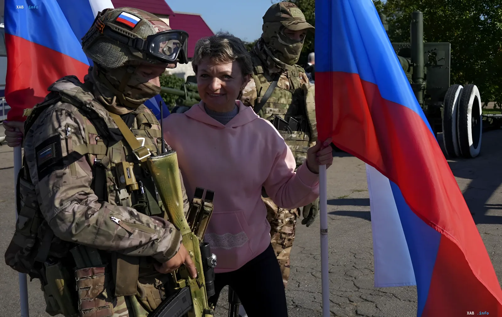 Female student in pink hoodie with Russian flag next to camouflaged soldiers, illustrating youth recruitment for TOT