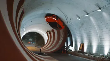 Oranges Elektroauto Voyah fährt an der Decke eines konischen Tunnels und führt einen Stunt aus, der dem Trick von Schumacher ähnelt