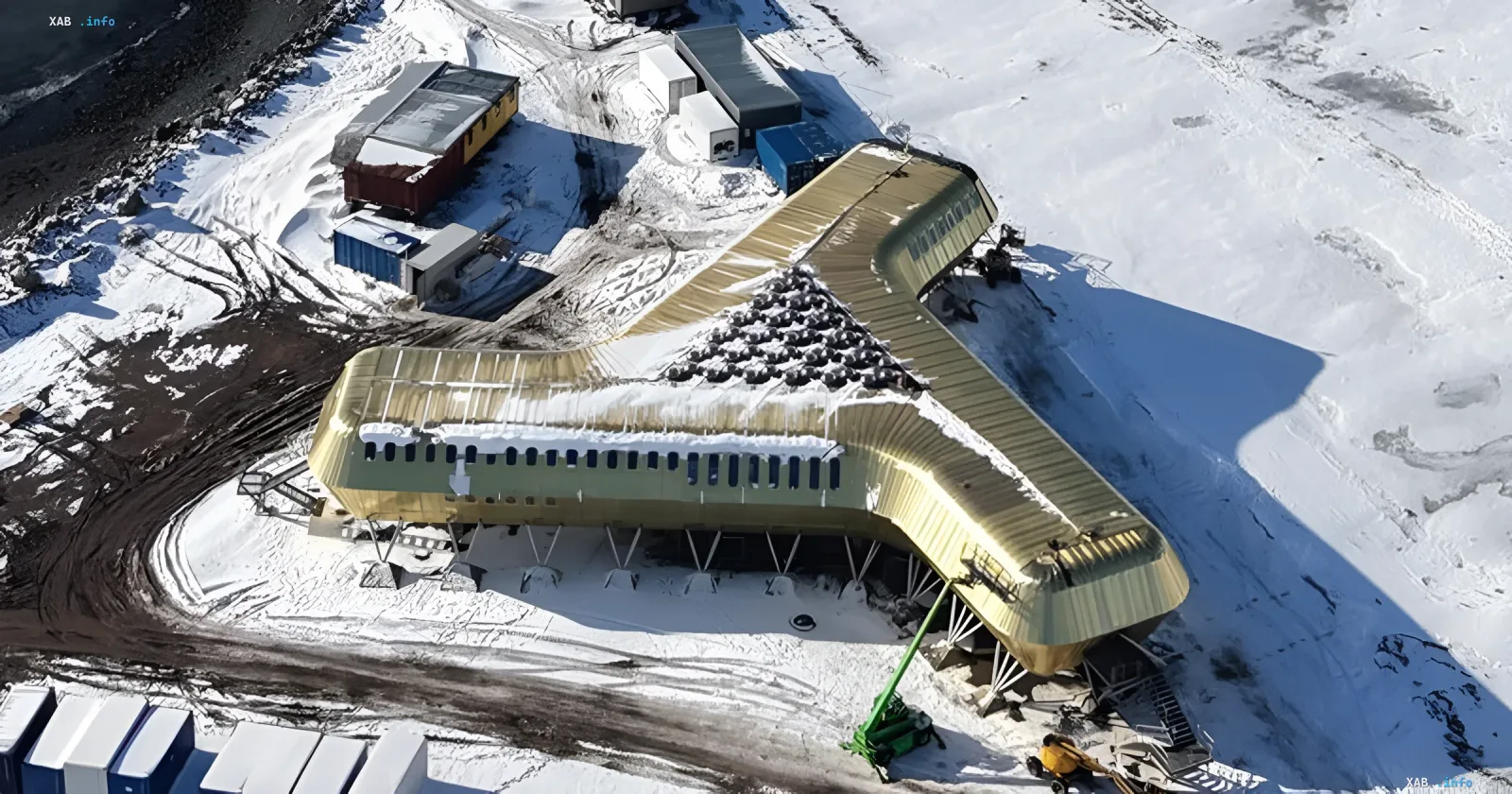 Golden wooden Antarctic station shaped like the letter Y, built on a snowy plateau with containers and equipment around