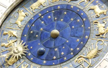 Astrologisches Tierkreiszeichen mit goldenen Symbolen auf blauem Hintergrund, das den Finsterniskorridor im August 2026 symbolisiert