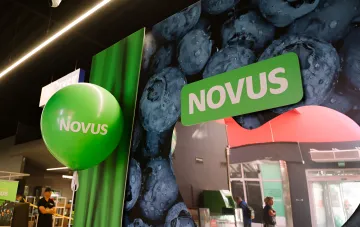 Вход в новый магазин Novus в Львове с ярким зеленым брендингом и изображением свежих ягод, символизирующий стратегическую экспансию сети на запад Украины