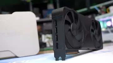 NVIDIA GeForce RTX 5090 graphics card with three fans and DisplayPort outputs against blurred gaming gear — visual for 6K gaming tests revealing flagship’s power limitations