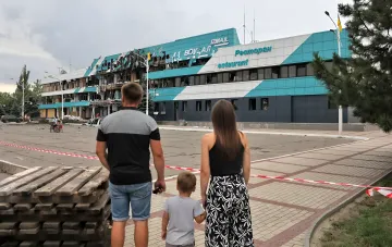 Семья смотрит на разрушенное здание вокзала в Измаиле, Украина, на фоне угрозы эскалации конфликта и обломков дронов на Дунае