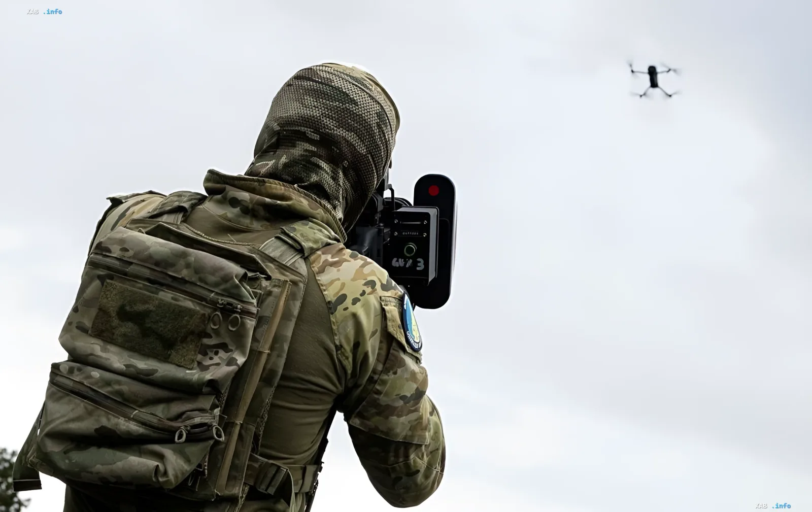 Украинский боец в камуфляже с противодроновым устройством нацеливается на российский дрон — иллюстрация к статье о финансовых потерях РФ от ударов ВСУ