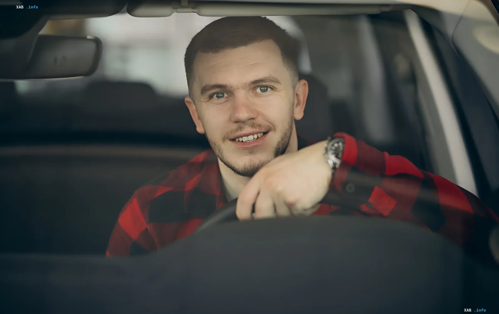Lächelnder Mann am Steuer eines Autos, der die Möglichkeit für ukrainische Fahrer symbolisiert, in Deutschland ohne Führerscheinprüfung zu fahren