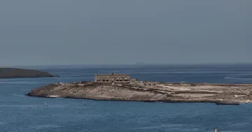 Заброшенное здание на острове в море, символизирующее остановку логистики и рост ставок фрахта