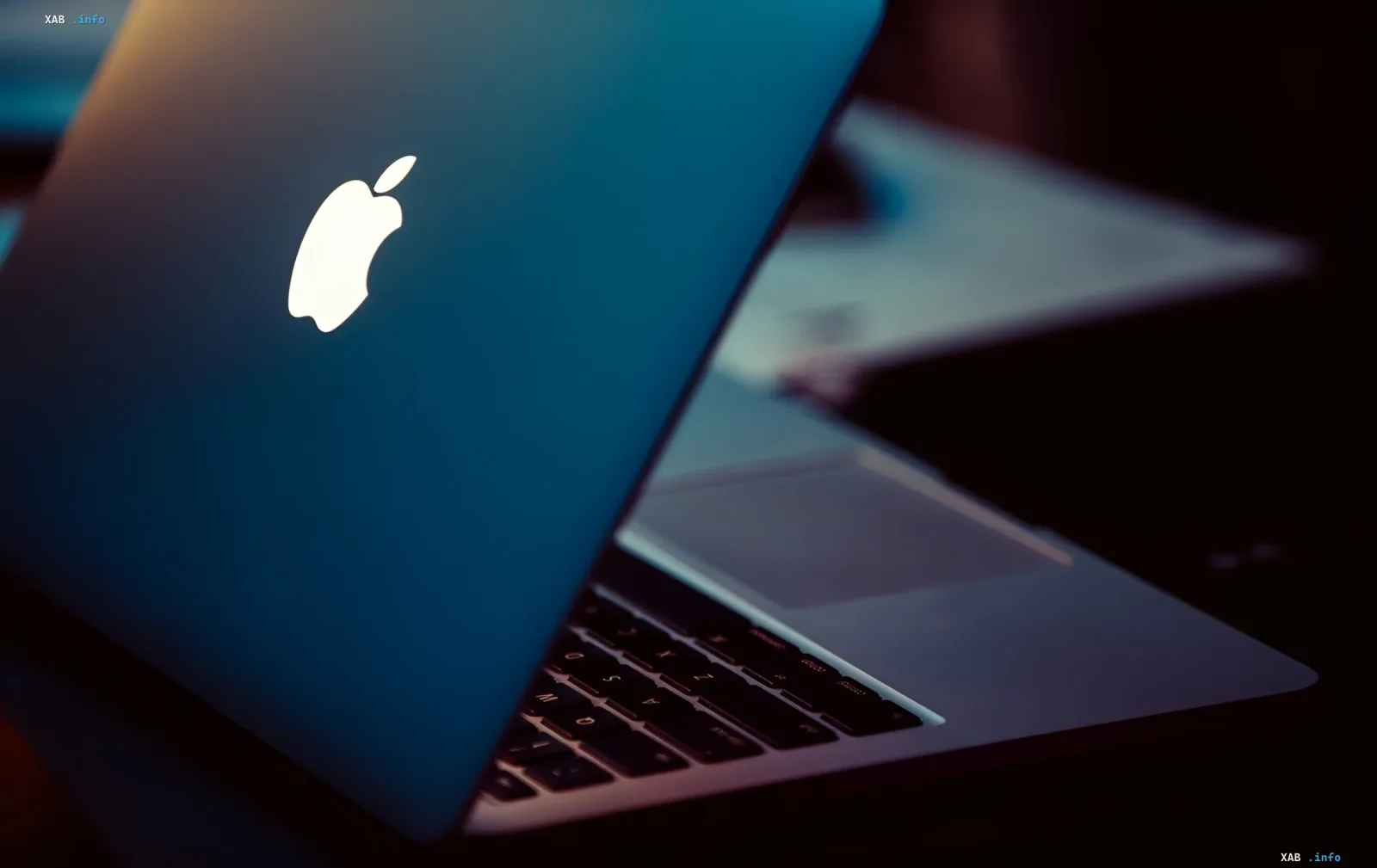 Ноутбук MacBook с логотипом Apple на фоне, символизирующий утечку информации из macOS Tahoe о новых устройствах Apple